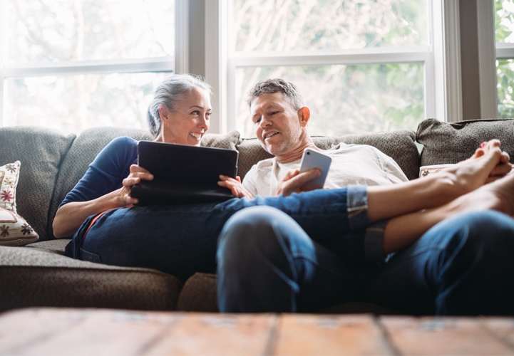 Älteres Paar auf Couch mit Tablet