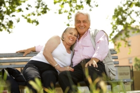 Älteres Paar auf einem Bank im Freien.