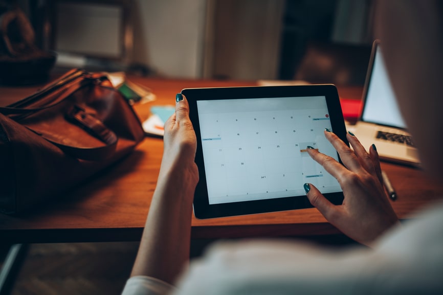 Person schaut auf dem Tablet in den Kalender