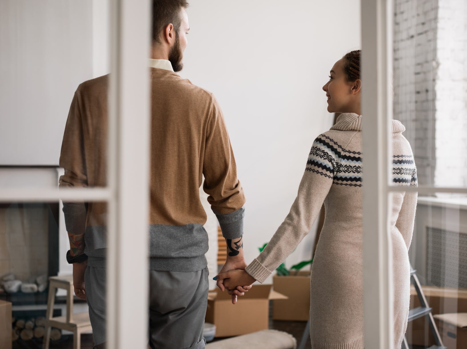 Mann und Frau Hand in Hand im Wohnzimmer